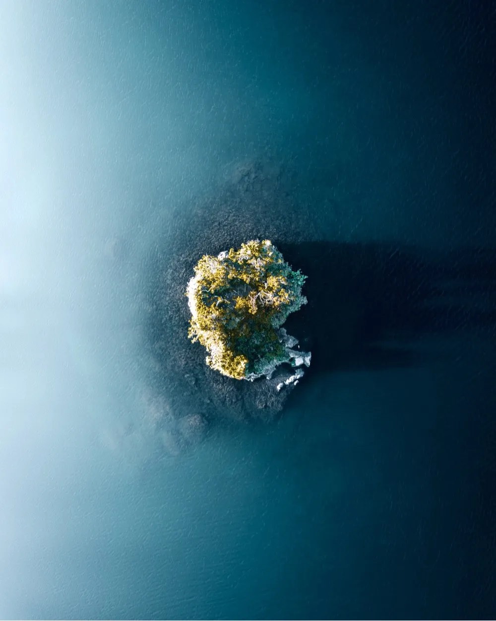photo of an island from above in the middle of a big blue sea